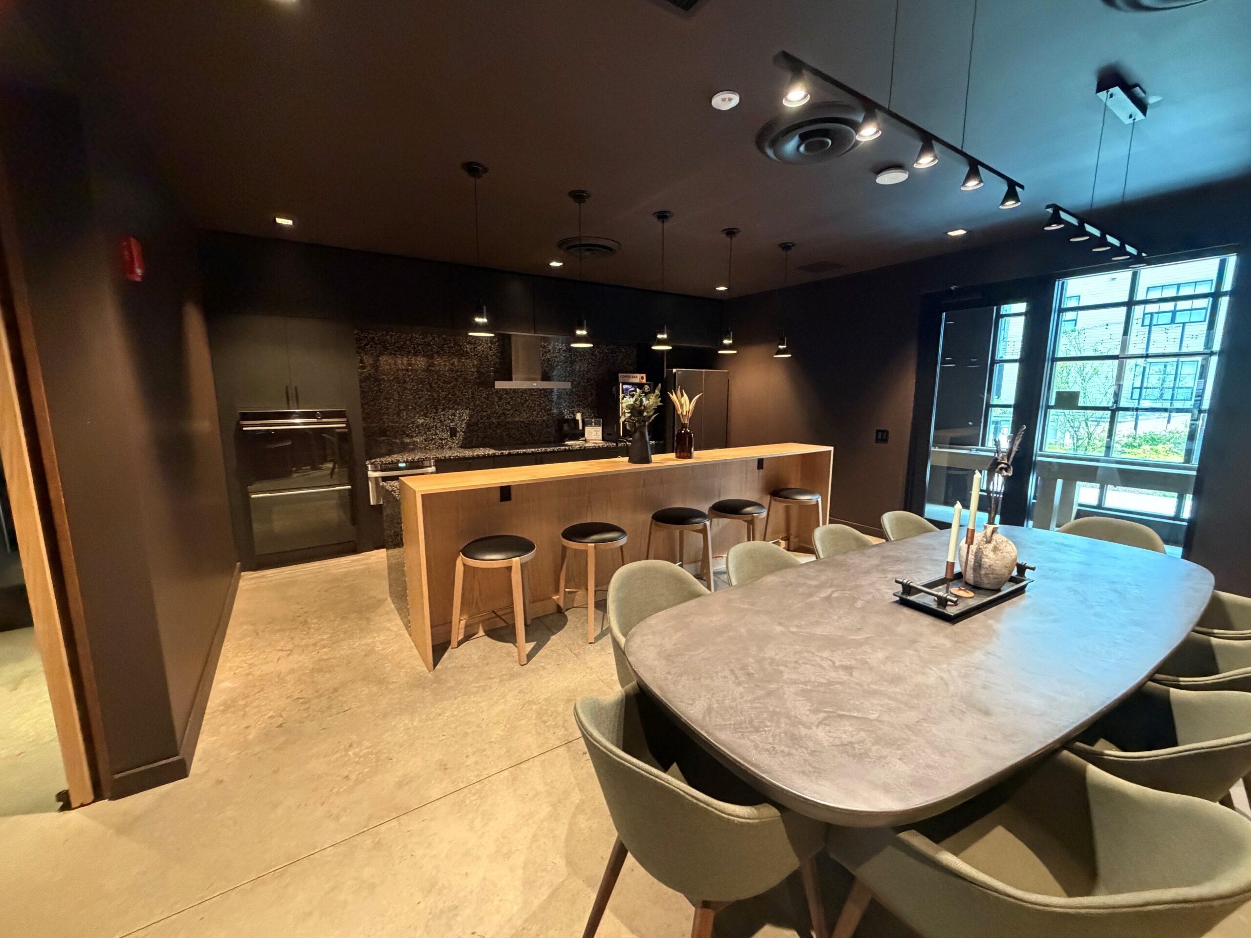 Community kitchen at The Winton Apartment community kitchen and lounge with a large island, bar stools, and pendant lighting