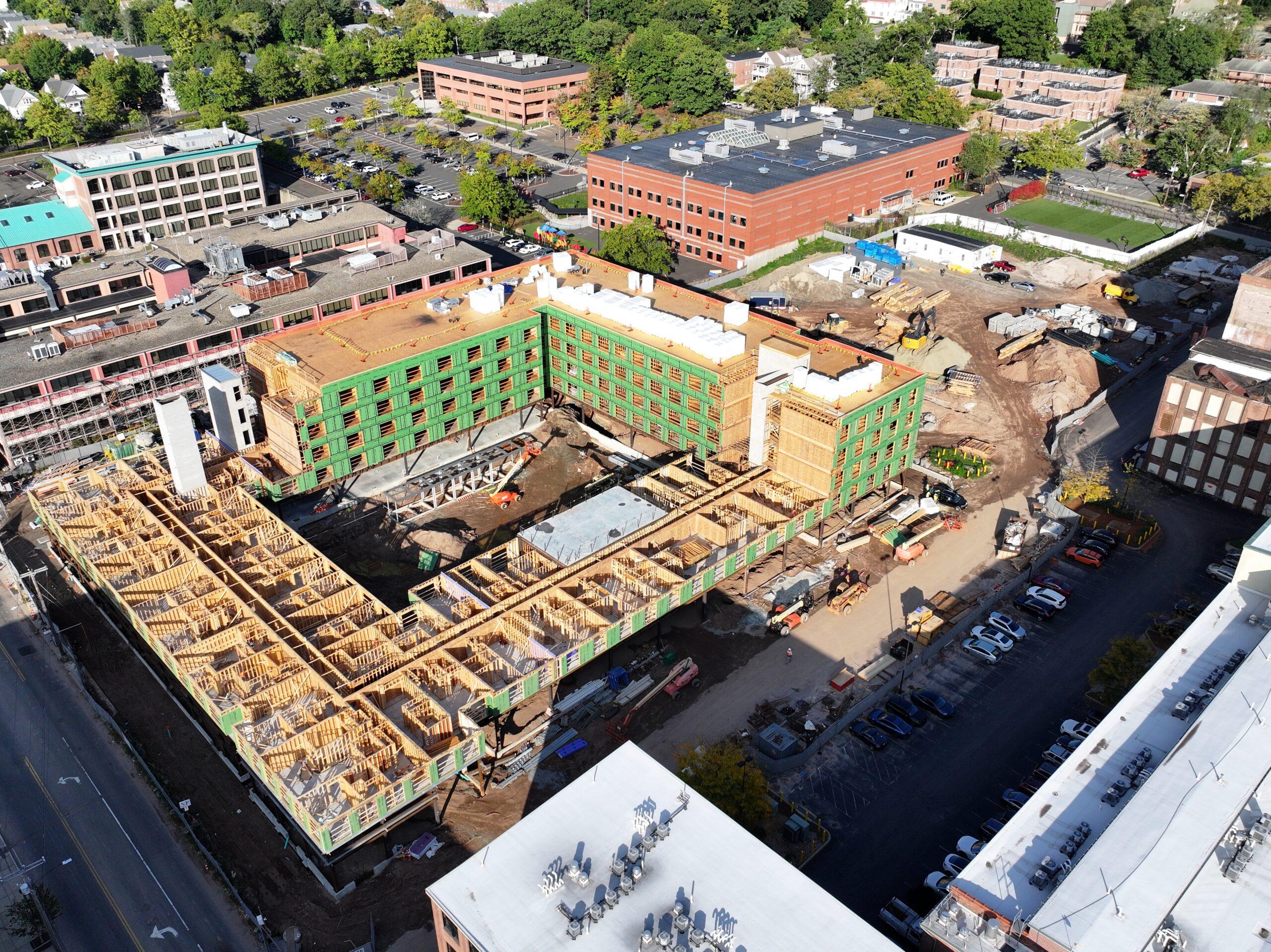 Aerial view of The Winston construction site Aerial view of an apartment building under construction with wood framing beside brick buildings