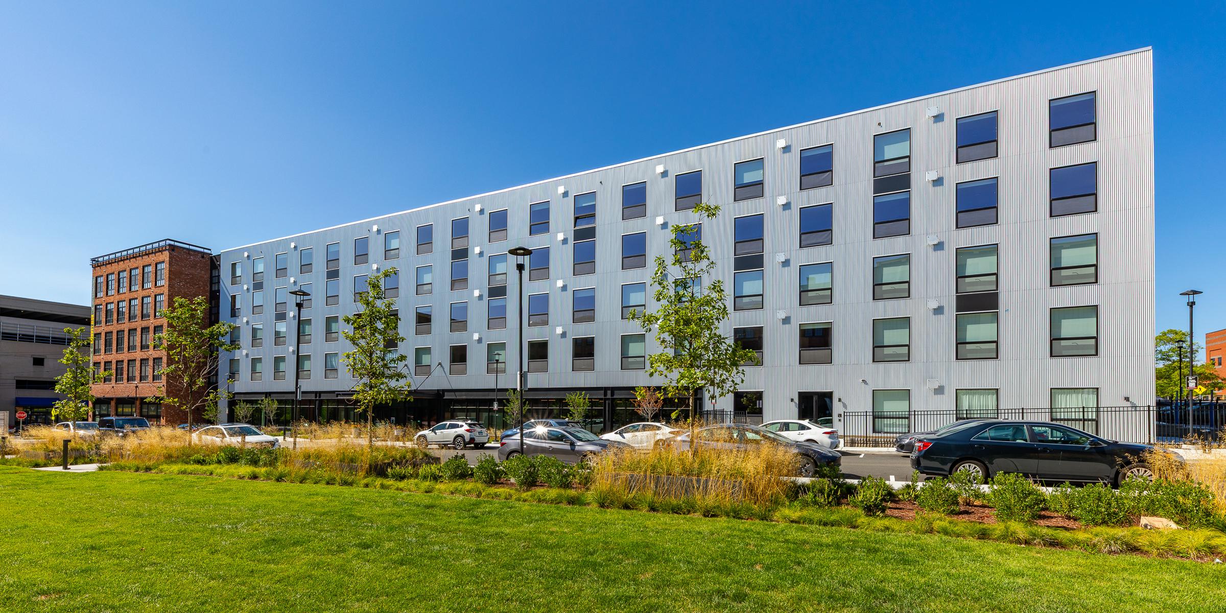 The Winston building Exterior of a modern white and gray apartment building with a landscaped lawn in front