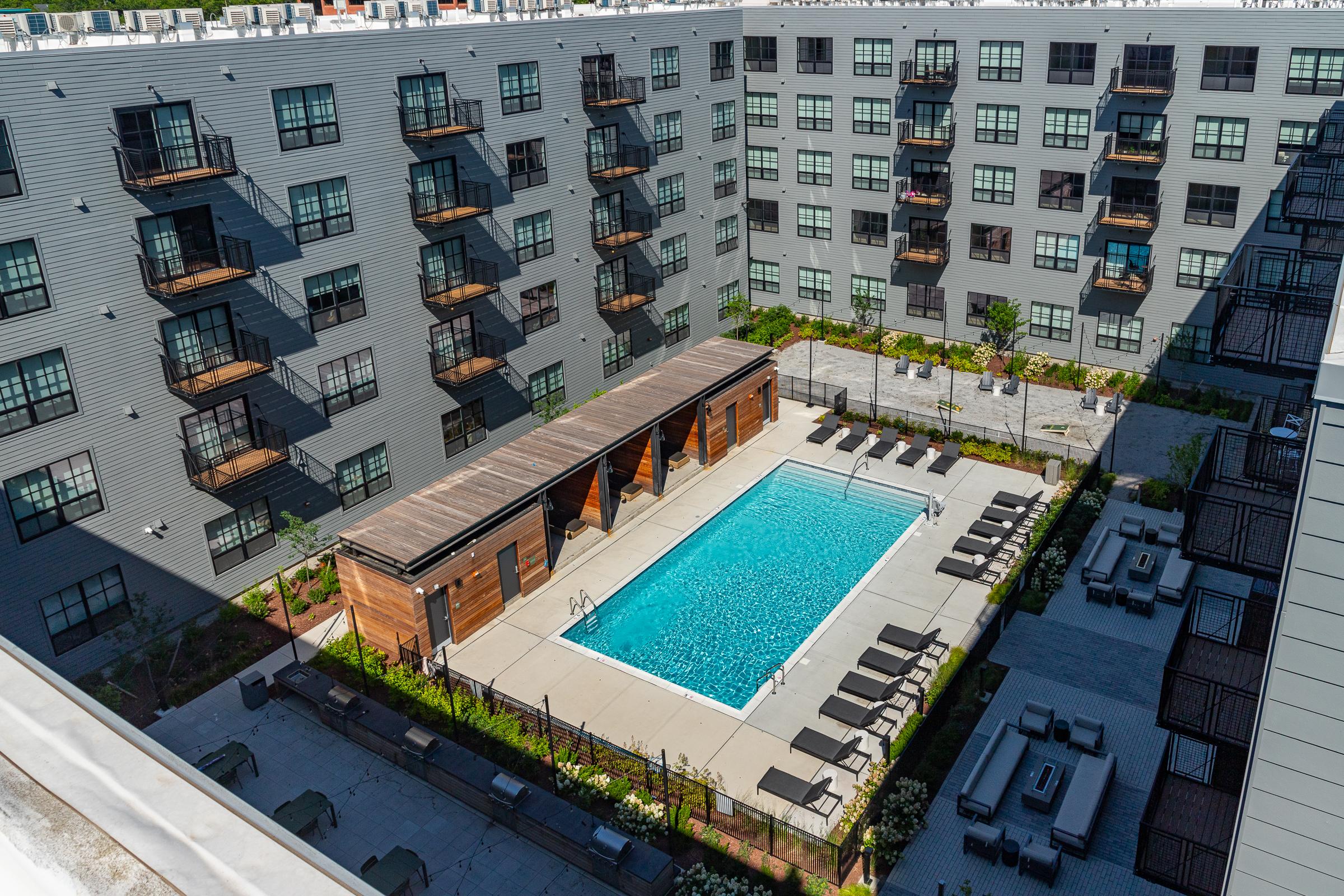 Aerial view of the pool at The Winston Elevated view of an apartment pool courtyard with lounge chairs beside the building