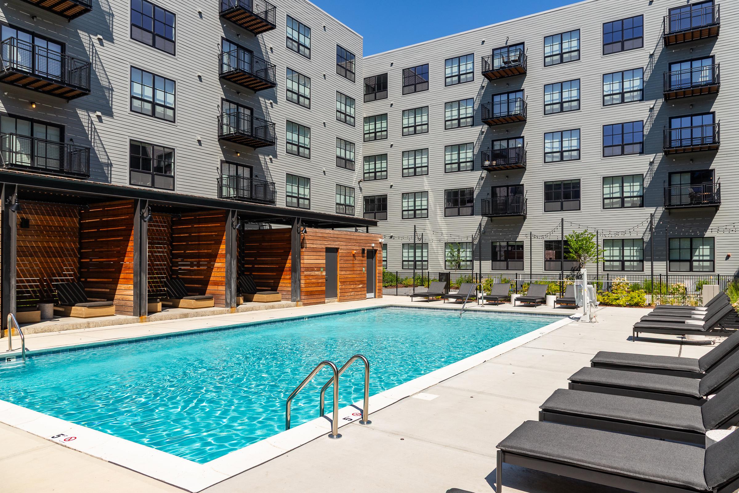Pool at The Winston Apartment pool area with cabanas and lounge seating beside the building